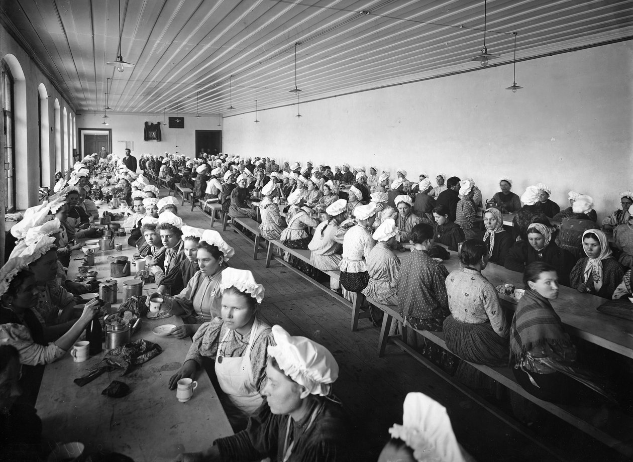 Lavoratrici in una fabbrica fanno una pausa pranzo, supervisionate da alcuni sorveglianti maschi da Russian Photographer
