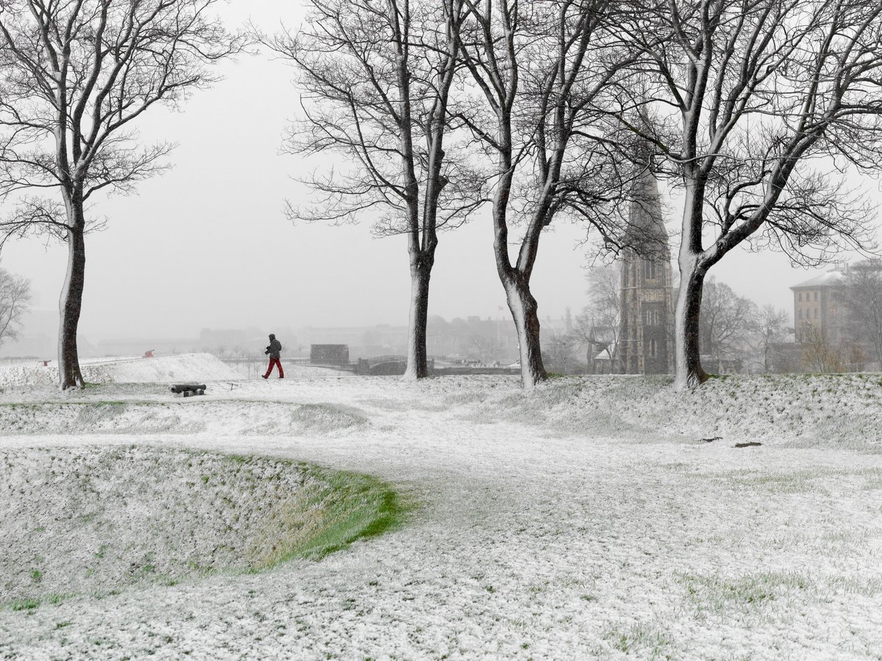 Figura solitaria che cammina nella Fortezza di Copenaghen durante una tempesta di neve, Danimarca, 2022 da Sisse Brimberg