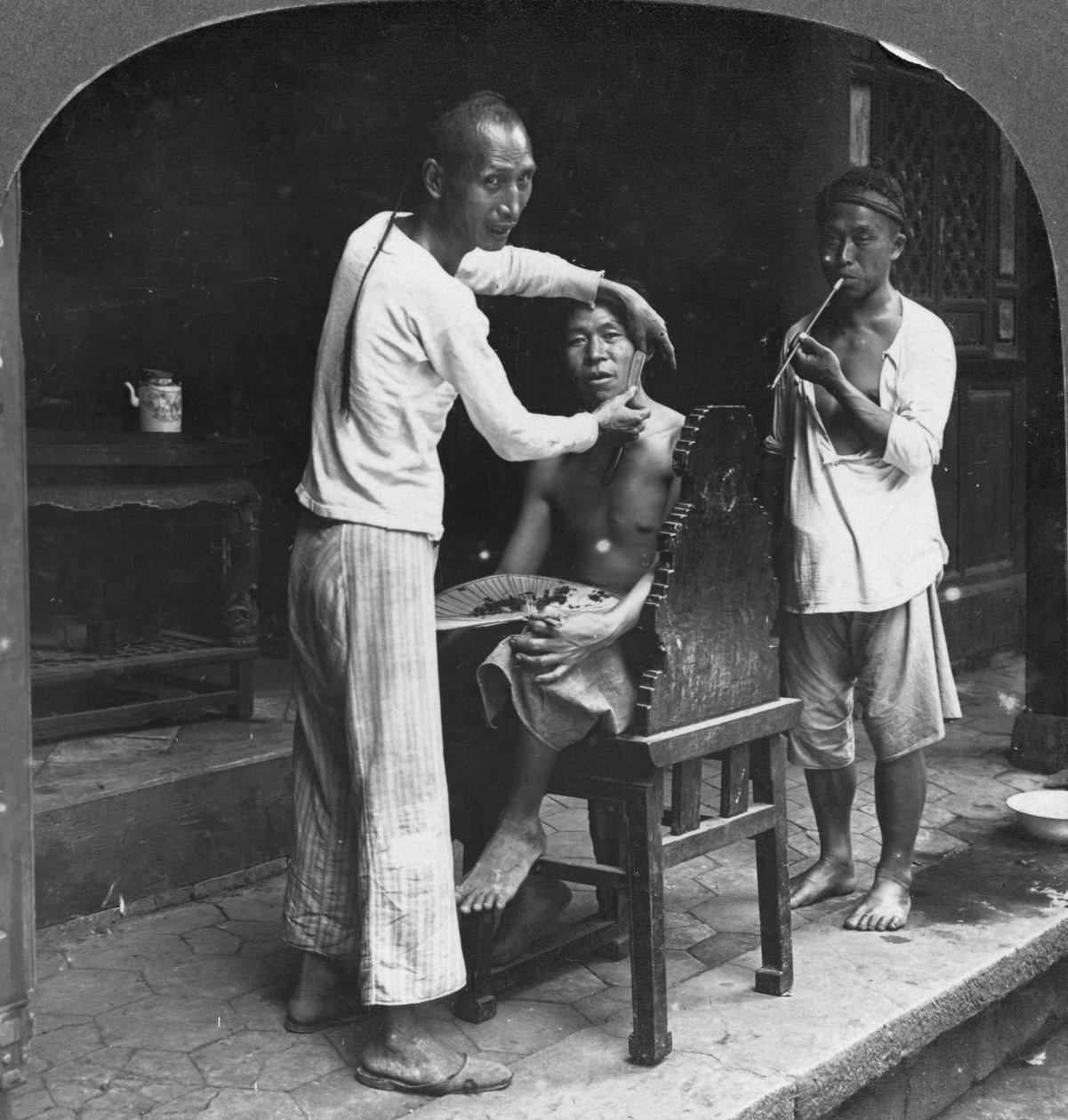 Un barbiere cinese a Bhamo, Birmania, 1908 da Stereo Travel Co