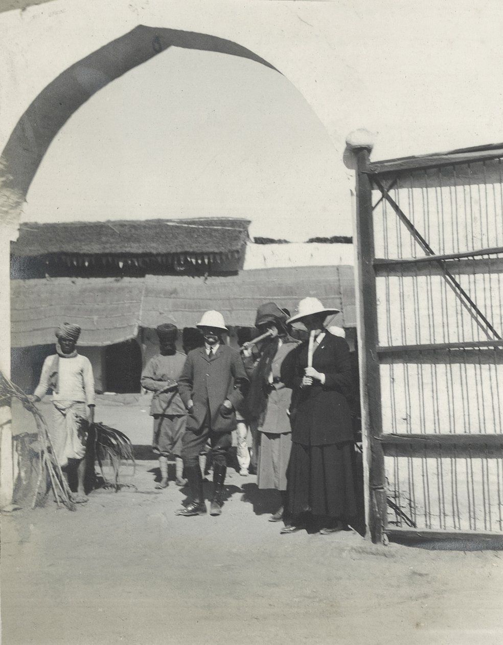 Il maggiore Gosling, Judy Smith e Lilah Wingfield che fumano canna da zucchero in una stazione di polizia vicino a Fatehpur Sikri, gennaio 1912 da Sylvia Brooke