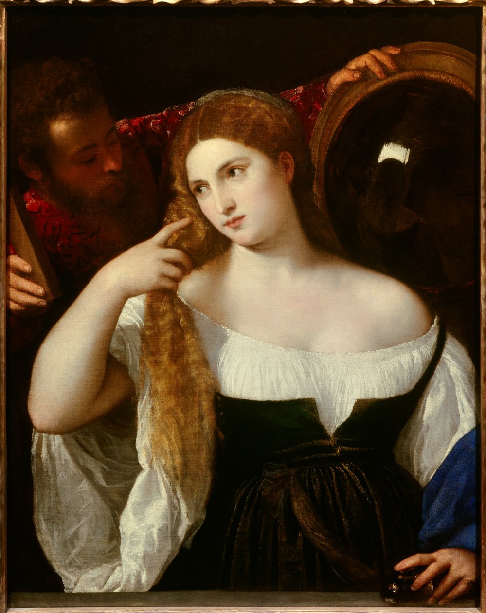 Ritratto di una donna con il suo toilette. Uno specchio dietro riflette la scena. Una serva tiene un altro specchio per lei, si guarda tranquillamente. La giovane donna sarebbe Laura Dianti, amante di Alfonso I d
