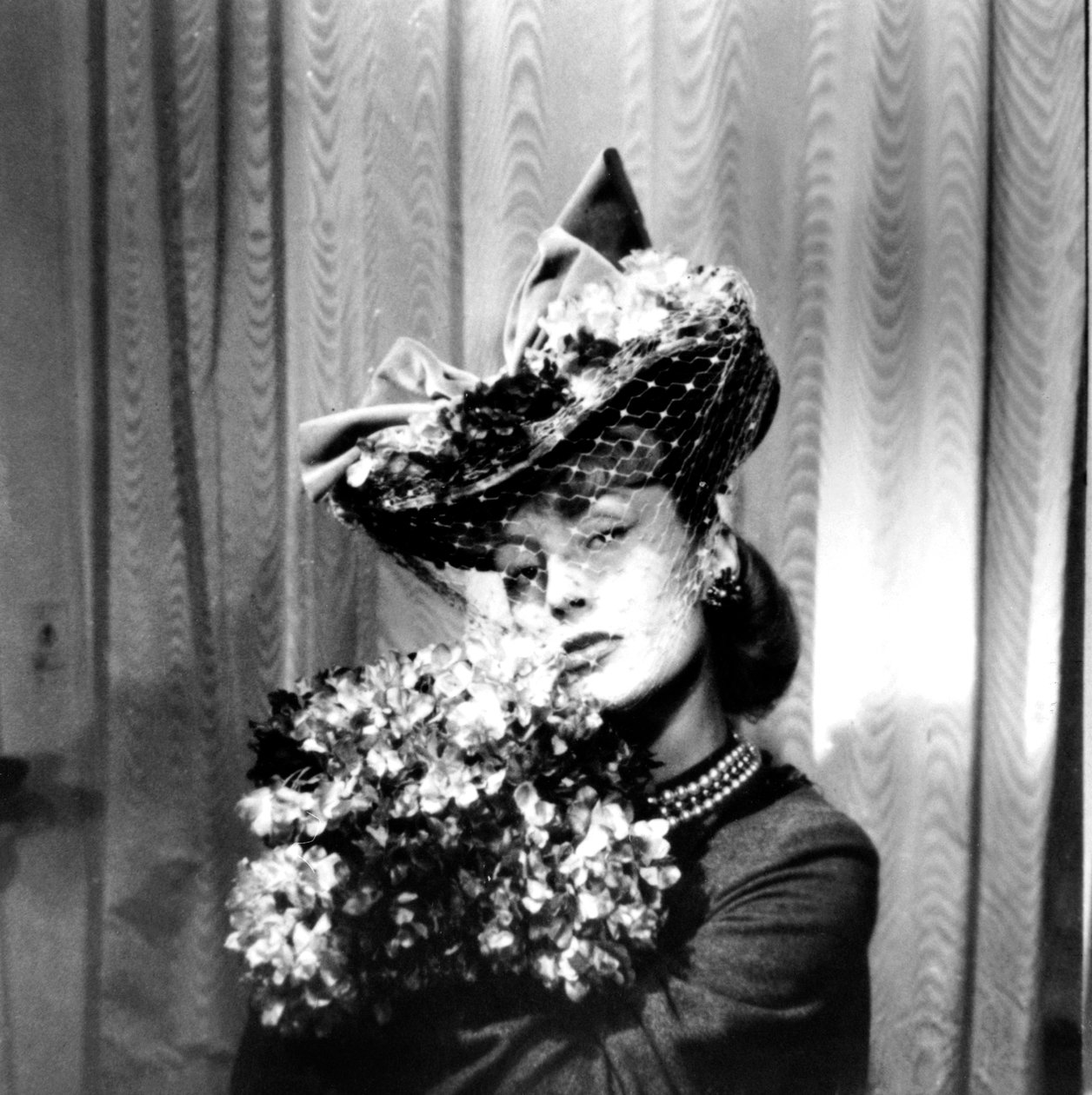 Donna con cappello con velo, che tiene un mazzo di fiori, Parigi, 1943 da Unbekannt