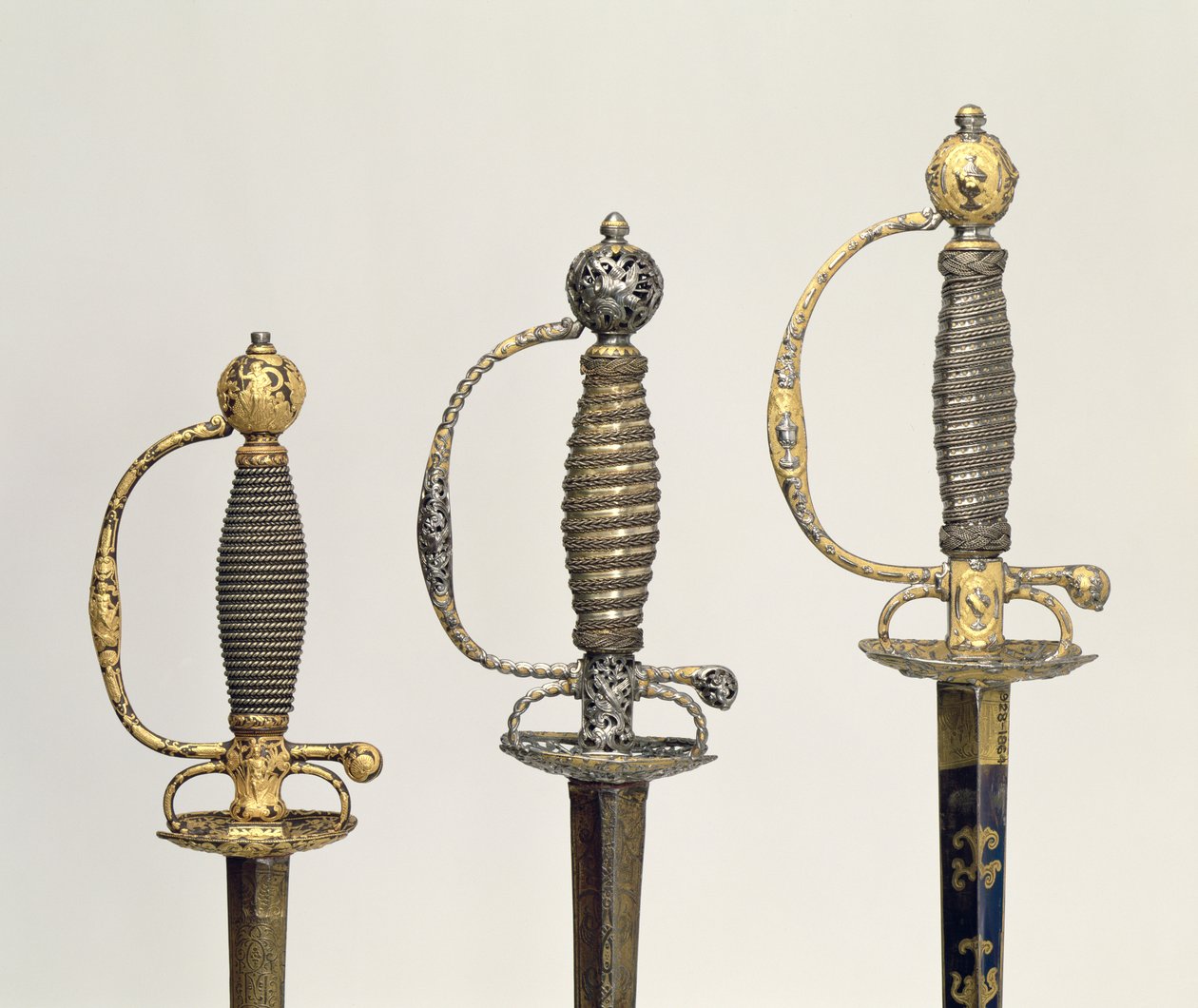 Elsa di tre spade francesi: una in acciaio, blu e decorata con disegni in oro cesellato, c.1730; una in acciaio traforato e cesellato e il fondo in oro opaco, c.1760; una in acciaio cesellato, gr da Unbekannt Unbekannt