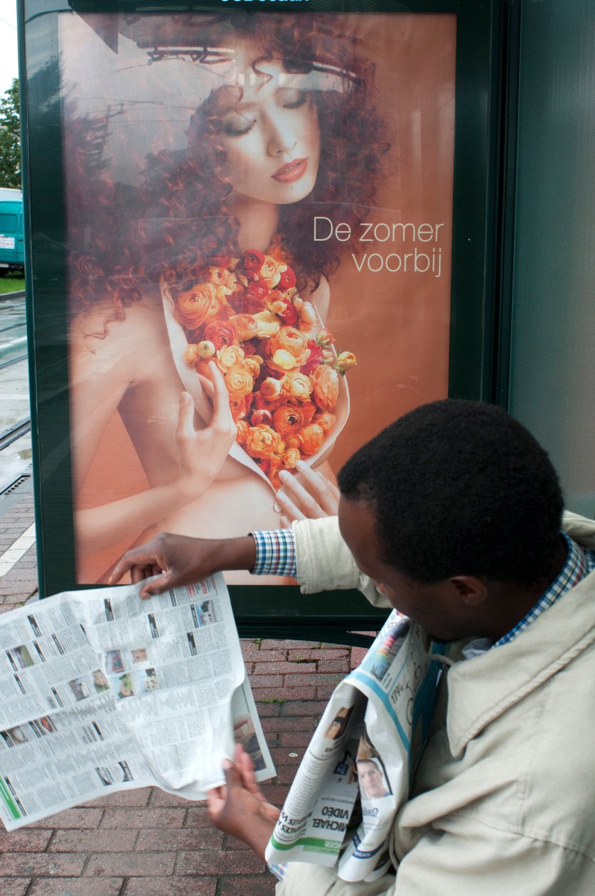 Uomo che legge un giornale alla fermata del tram di Bruxelles, Belgio da Unbekannt Unbekannt