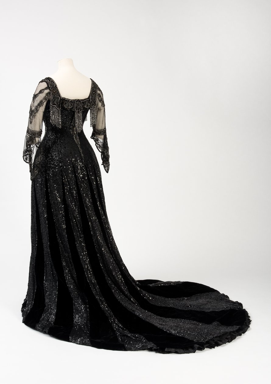 Abito da sera nero indossato dalla regina Alessandra, con decorazioni di perline e paillettes e incorporante il nastro di seta nera e lettere dorate con il nome della regina Alessandra, realizzato da Barolet di Knightsbridge, Londra 1908-1910 da Unbekannt