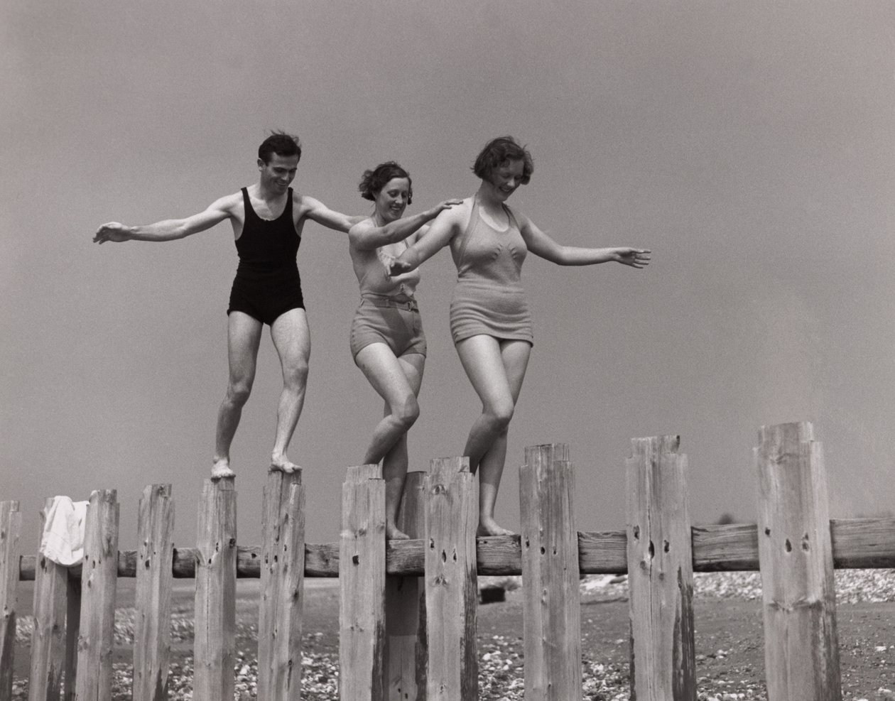 Due donne e un uomo che camminano lungo una diga, c 1930 da Unbekannt