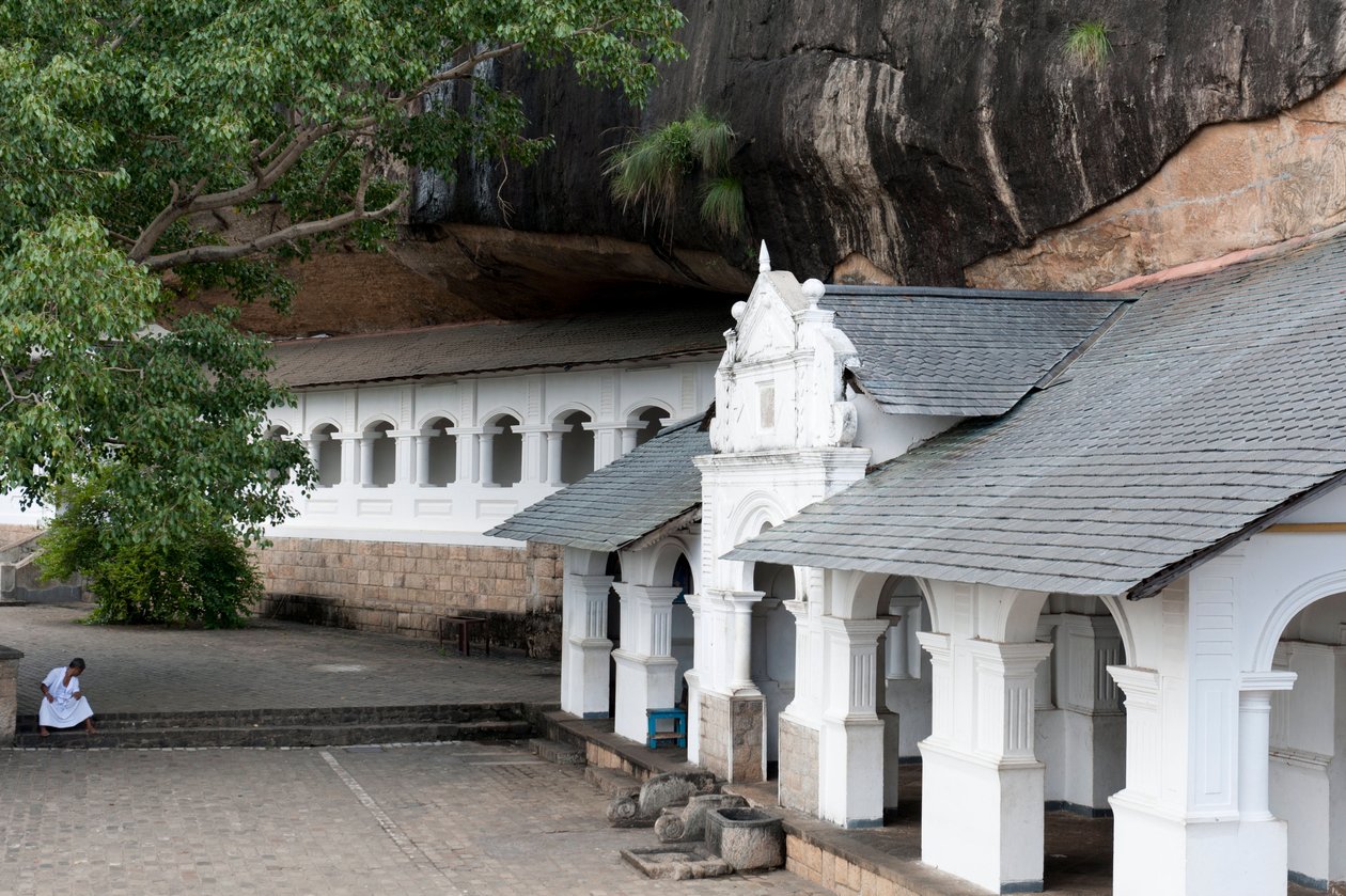 Edificio bianco sotto una parete rocciosa; tempio rupestre; Tempio d