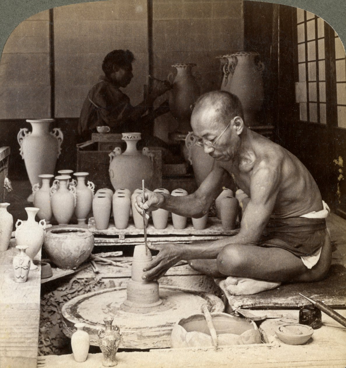 Un vasaio e la sua ruota, modellando un vaso di porcellana Awata, opere di Kinkosan, Kyoto, Giappone, 1904 da Underwood and Underwood