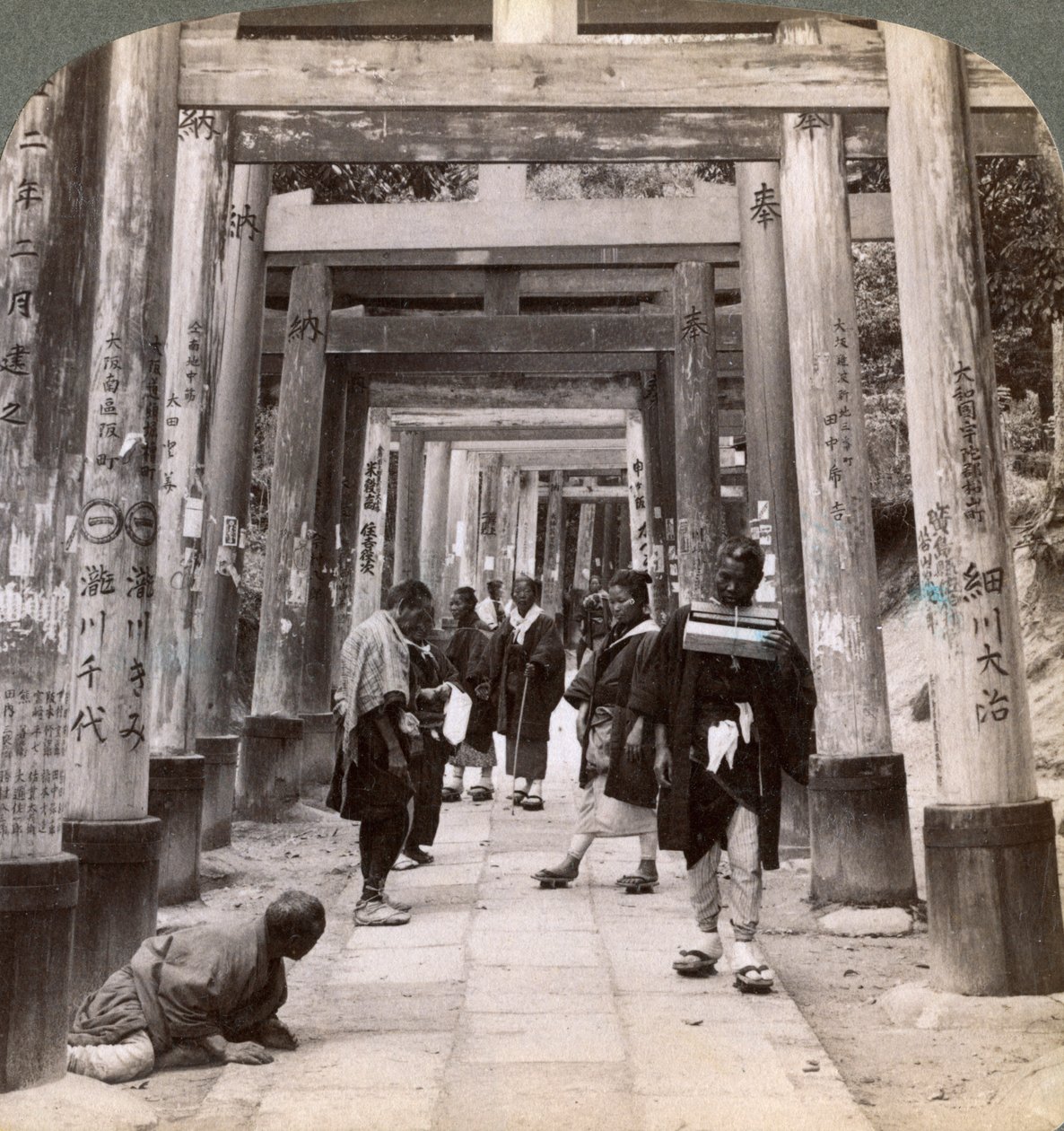 Andare e venire sotto lunghe file di torii sacri, tempio shintoista di Inari, Kyoto, Giappone, 1904 da Underwood and Underwood