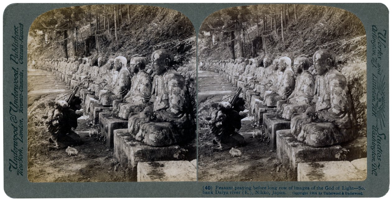 Contadino che prega davanti a una fila di statue del Dio della Luce, fiume Daiya, Nikko, Giappone da Underwood and Underwood