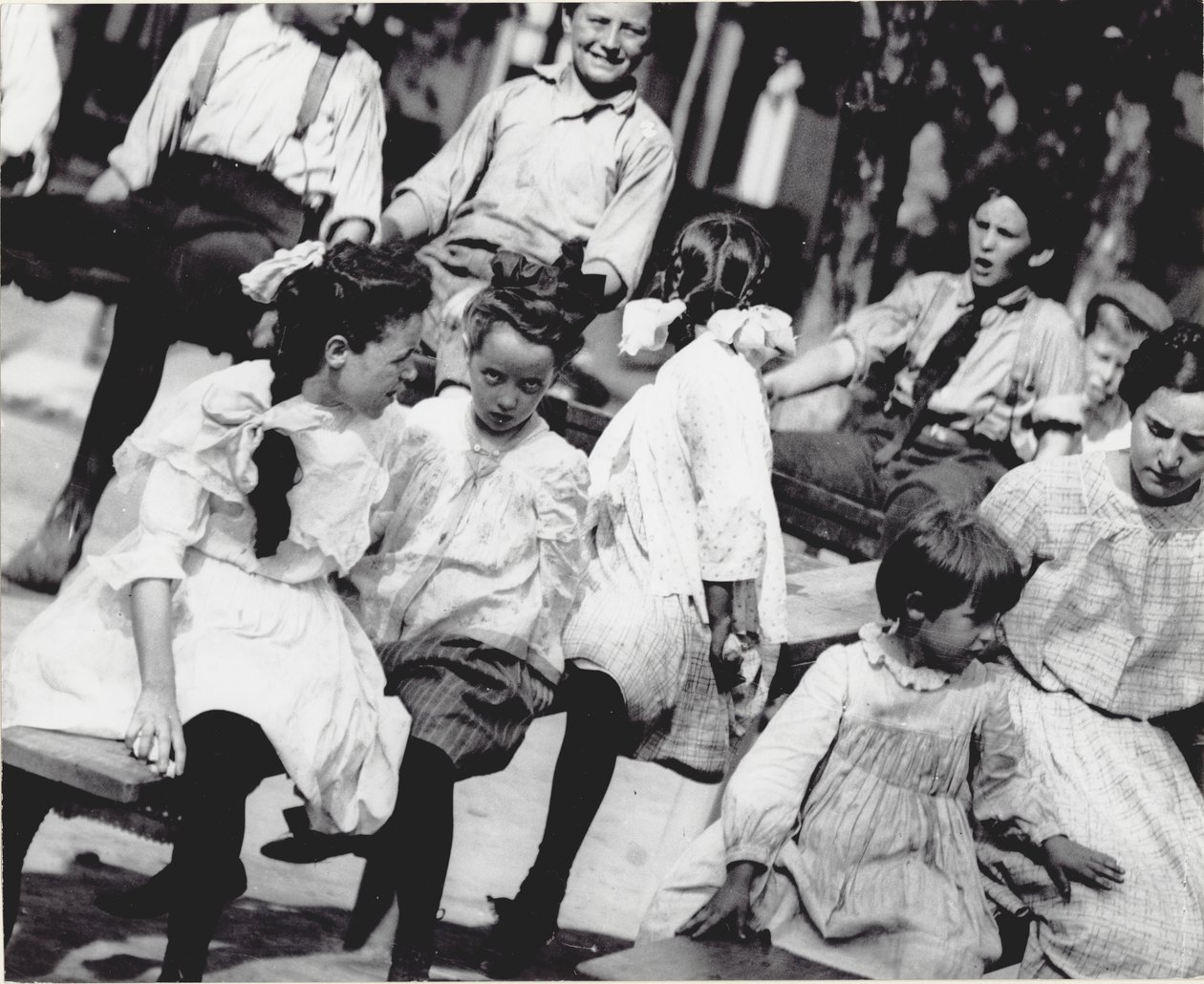 Un gruppo di bambini che giocano sulle altalene in un parco non identificato da Unknown