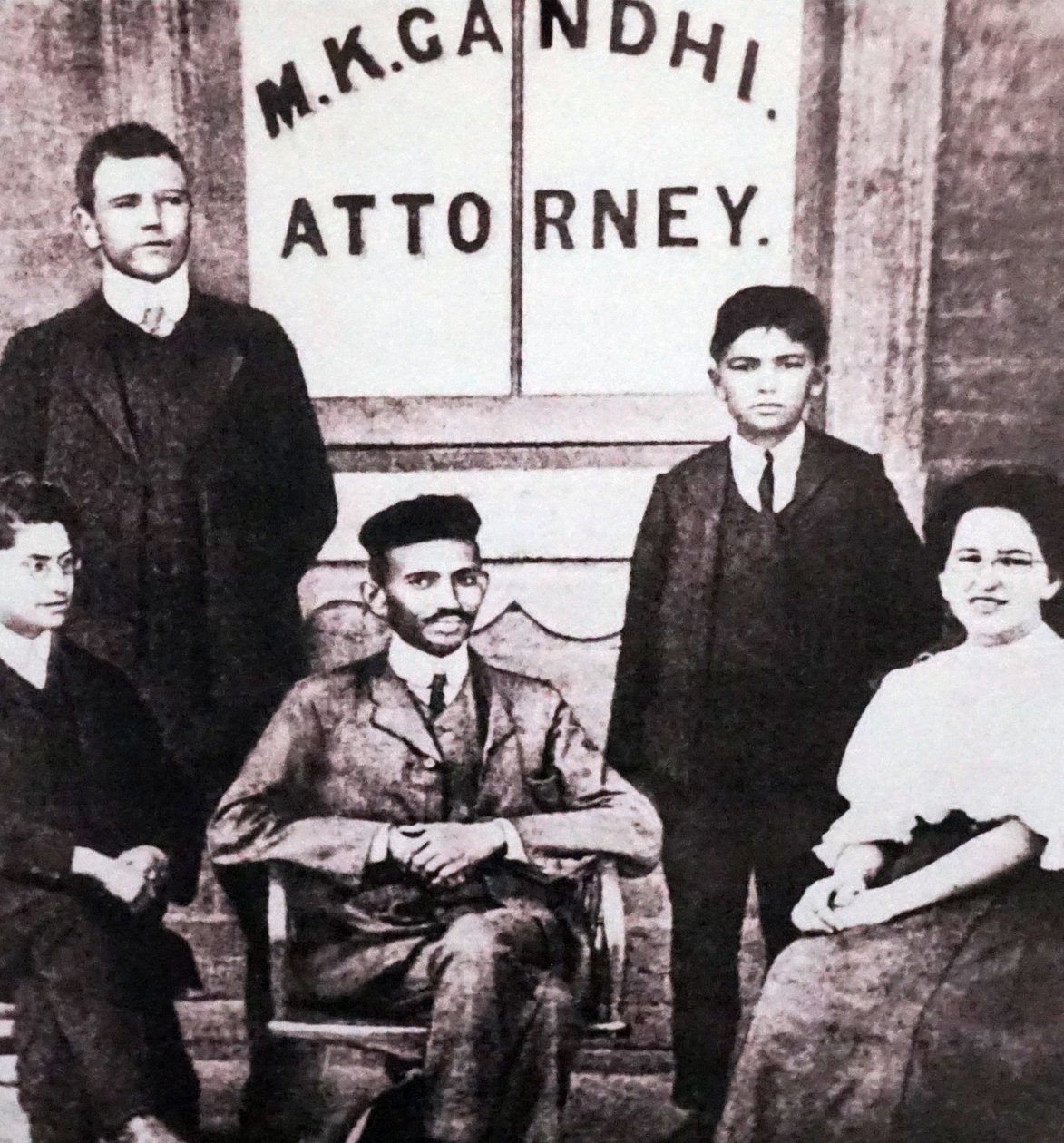 Mahatma Gandhi seduto con quattro collaboratori davanti al suo studio legale a Johannesburg, Sudafrica, Sudafrica da Unknown photographer