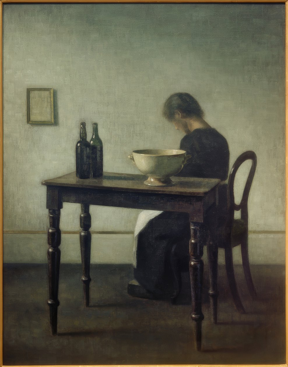 Donna seduta dietro un tavolo da Vilhelm Hammershoi