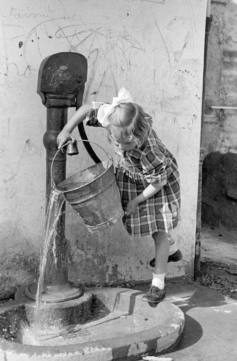 Bambina che svuota un secchio d