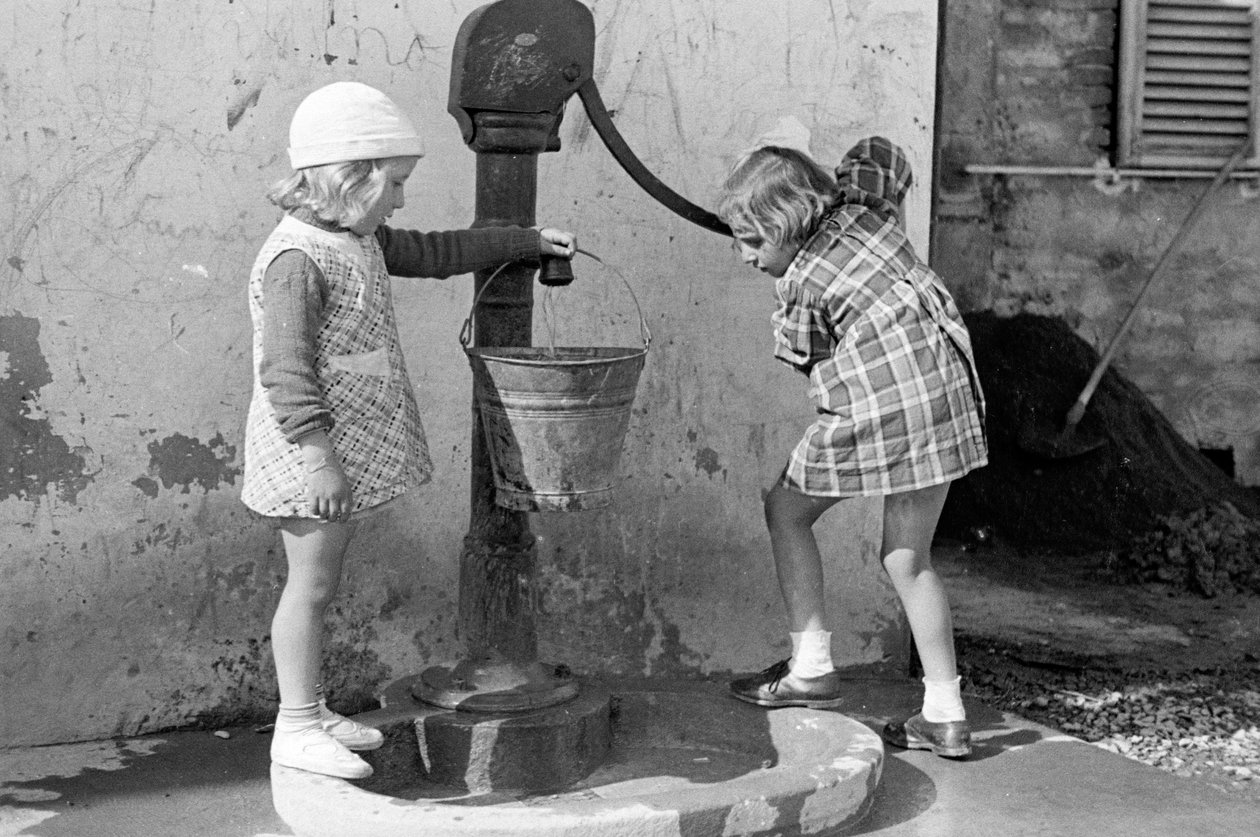 Bambine che riempiono un secchio d