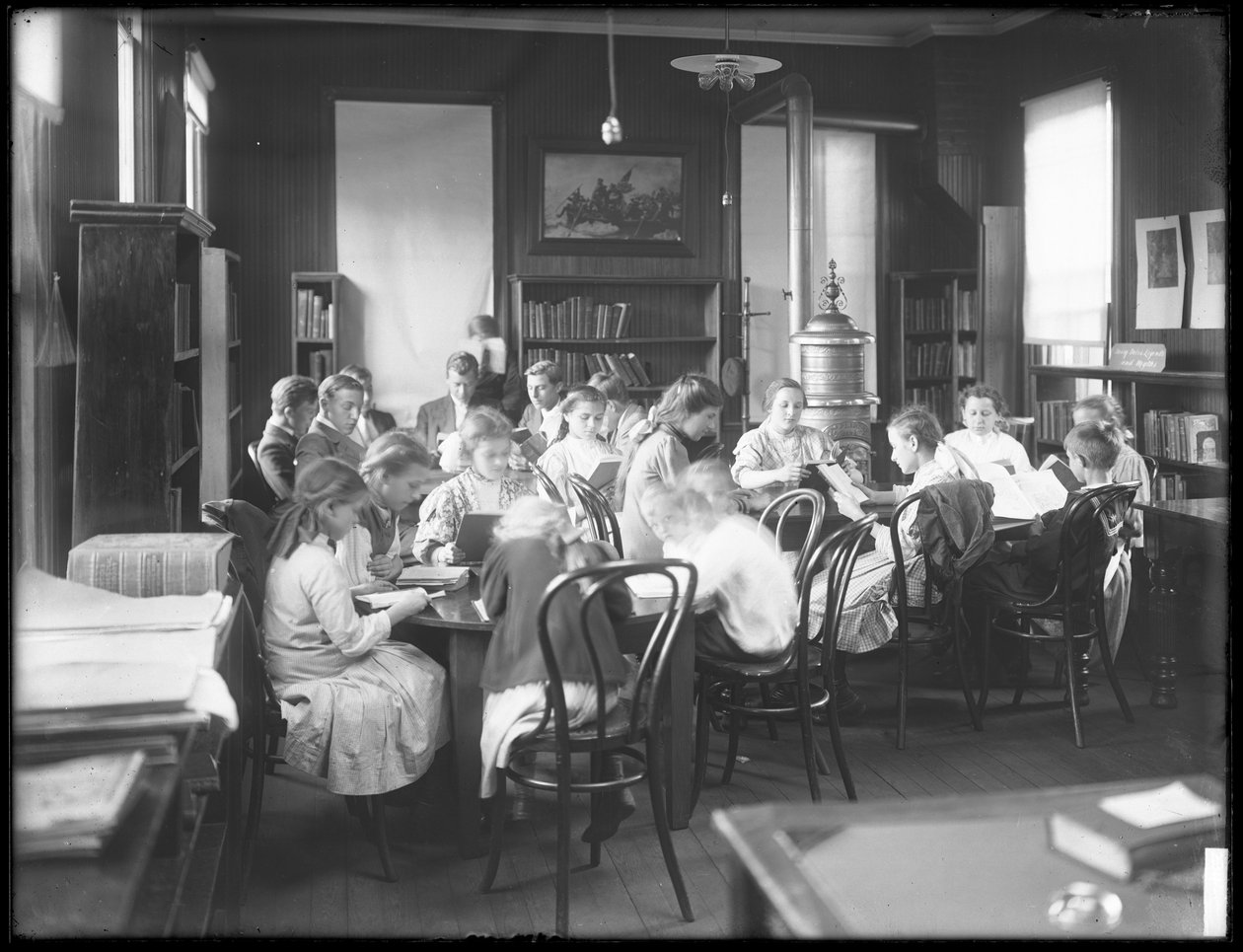 Bambini che leggono nella sala di lettura di una filiale non identificata della Queens Borough Public Library, c.1910 da William Davis Hassler