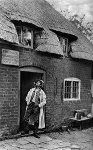 Un uomo che fuma una pipa fuori da un negozio, Worcestershire, c1922