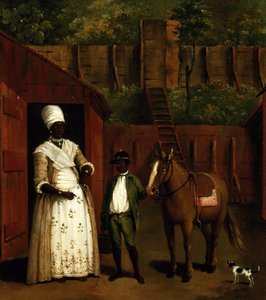 Una madre e un figlio nero con un pony fuori da una stalla