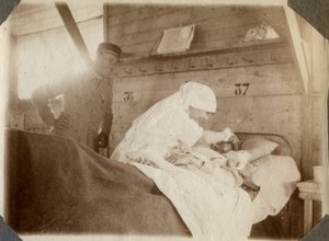 Prima Guerra Mondiale 1914-1918: infermiera in camice che rade un soldato (ferite di guerra francesi giacciono in un letto), a Couville, Manche, Bassa Normandia, Francia. Fotografia anonima luglio 1917. Collezione privata, Stella.