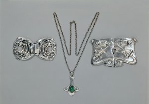 Gioielli in argento progettati per Liberty. Da sinistra a destra: Fermaglio per vita con design celtico intrecciato, 1904. Pendente e catena con crisoprasio cabochon. Fermaglio per vita con design a rilievo su martellato da Archibald Knox