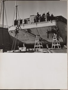[Un gruppo di uomini lavora su una barca attraccata]