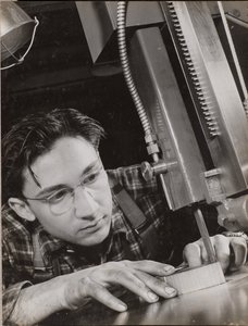 [Uomo con occhiali lavora intensamente con una lima industriale] da Arnold Eagle