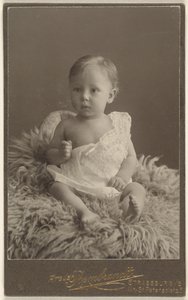 [Bambino non identificato seduto su un tappeto di pelle d