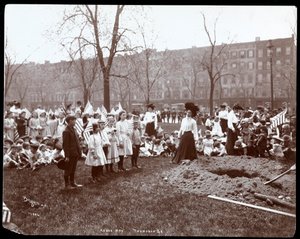 Adulti e bambini con bandiere intorno a una buca appena scavata per la piantagione di un albero nel Tompkins Square Park, New York