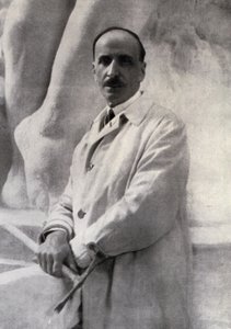Ritratto a tre quarti dello scultore Edoardo Rubino con martellina in mano. Sullo sfondo si intravede una scultura