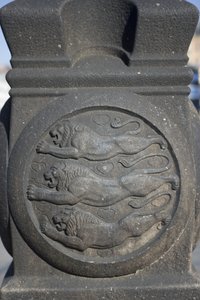 Tre leoni scolpiti in una colonna di pietra nella Piazza del Municipio