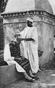Un barbiere di strada e il suo cliente, Algeria, Africa, 1922 da Donald McLeish
