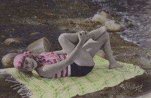 Ragazza sdraiata su un asciugamano sulla spiaggia