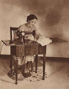 Casalinga al lavoro sulla macchina da cucire, metà anni 
