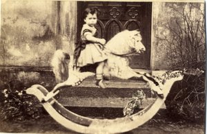 Bambina su un grande cavallo a dondolo in un giardino, 1860s da English Photographer