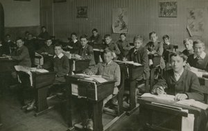 Alunni maschi seduti dietro i loro banchi durante una lezione a scuola da English Photographer