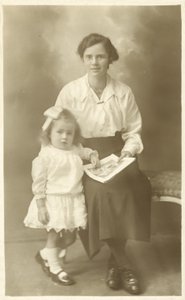 Bella ragazza, madre o governante, che mostra foto a un bambino piccolo da English Photographer