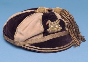 Cappello da calcio segmentato blu e bianco con distintivo di drago in metallo e nappa d
