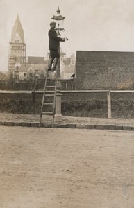 Uomo su una scala che ripara un lampione