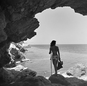 Bagnante sulla scogliera che guarda il mare presso il villaggio di Aspra, vicino a Palermo, Sicilia, 1950 circa (foto b/n) da Fosco Maraini