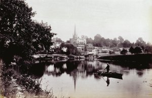 La città di Ross-On-Wye, vista da una riva del fiume. In primo piano un uomo in piedi su una barca a remi da Francis Frith
