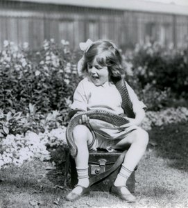 Una giovane ragazza Betty che tiene un serpente indaco orientale, mentre è seduta su un baule di pelle, Zoo di Londra, 1924 da Frederick William Bond