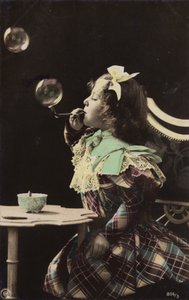 Una bambina che soffia bolle da una pipa da French Photographer