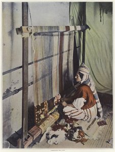 Una donna che tesse un arazzo su un telaio in Tunisia da French Photographer