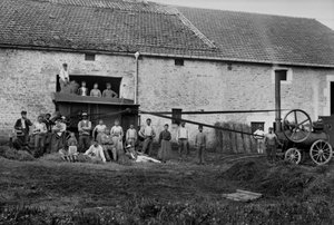 Lavoratori agricoli e la pressa legano balle di fieno in una fattoria vicino a Bourmont in Haute-Marne (Haute Marne), intorno al 1890. Fotografia. Collezione Ducos. da French Photographer