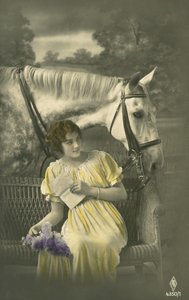 Ragazza seduta sul divano con un cavallo bianco dietro (foto a colori)