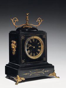 Un orologio da mensola in pietra composita nera, con decorazioni incise, con gambe, pinnacoli e raccordi in ottone dorato, di Jausions di Pau, Francia da French School