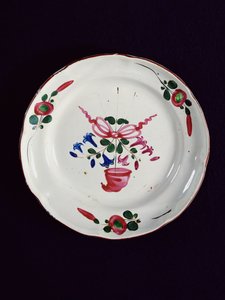 Piatto con decorazione di un bouquet sormontato da un berretto frigio