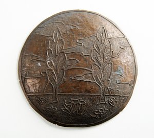 Placca convessa con alberi, nuvole e fiori