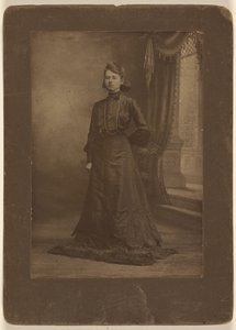[Ritratto di una giovane donna in abito nero lungo, in piedi]. da George W. Killian