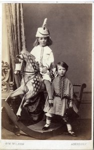 Ragazzina con cappello su cavallo a dondolo con un
